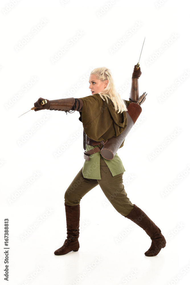 full length portrait of a blonde girl wearing green and brown medieval costume, holding a bow and arrow. isolated on white background. full length portrait of a blonde girl wearing green and brown medieval costume, holding a bow and arrow. isolated on white background.