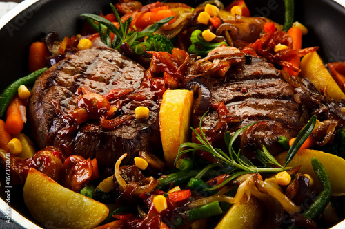 Foto Grilled steaks and vegetables