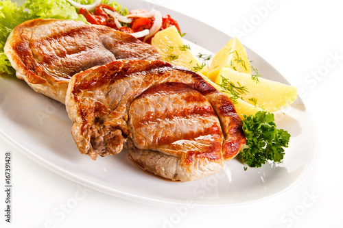 Grilled steak, boiled potatoes and vegetable salad on white background