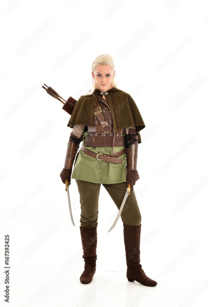 full length portrait of a blonde girl wearing green and brown medieval costume, holding a bow and arrow. isolated on white background. full length portrait of a blonde girl wearing green and brown medieval costume, holding a bow and arrow. isolated on white background.