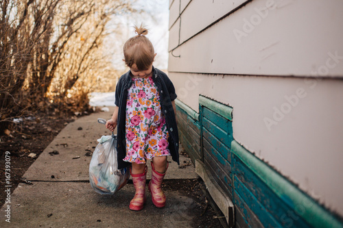 Toddler Girl Taking Out Some Trash photo