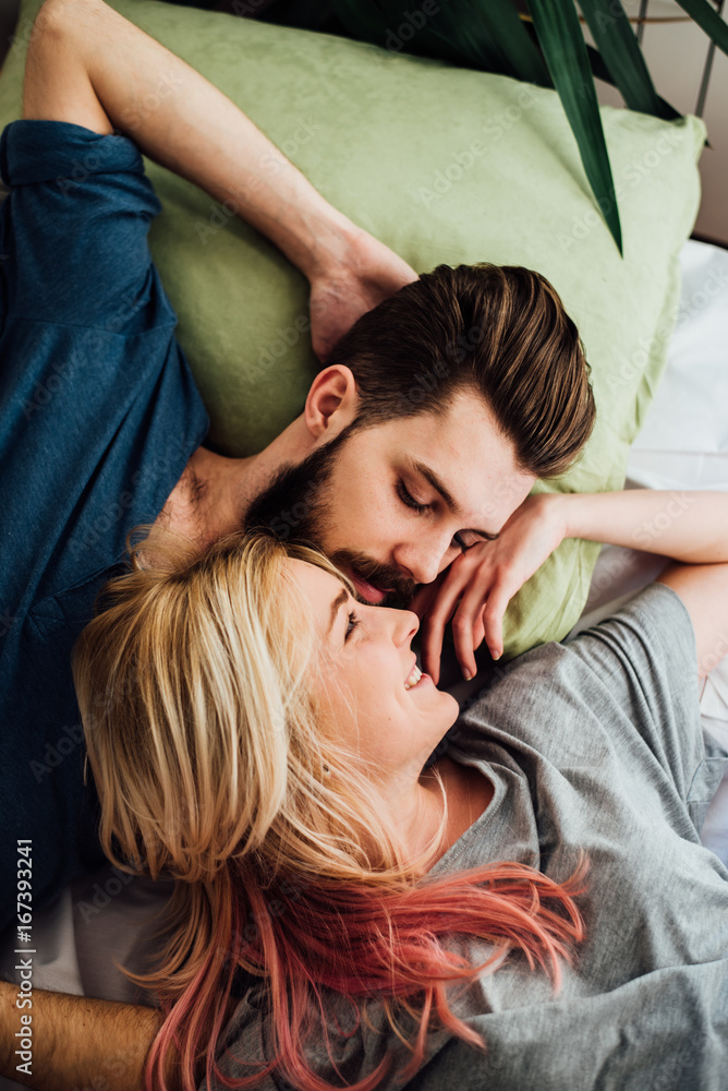 Pretty Young Couple Cuddling While Laying in the Bed Pretty Young Couple Cuddling While Laying in the Bed