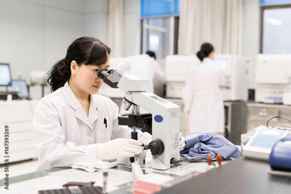 Scientists using equipments in lab Scientists using equipments in lab