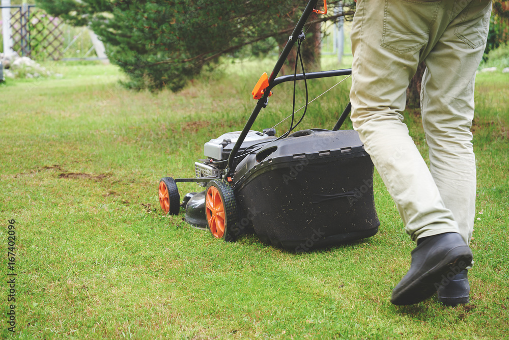 Lawnmower at work on countryside house lawn. Lawnmower at work on countryside house lawn.