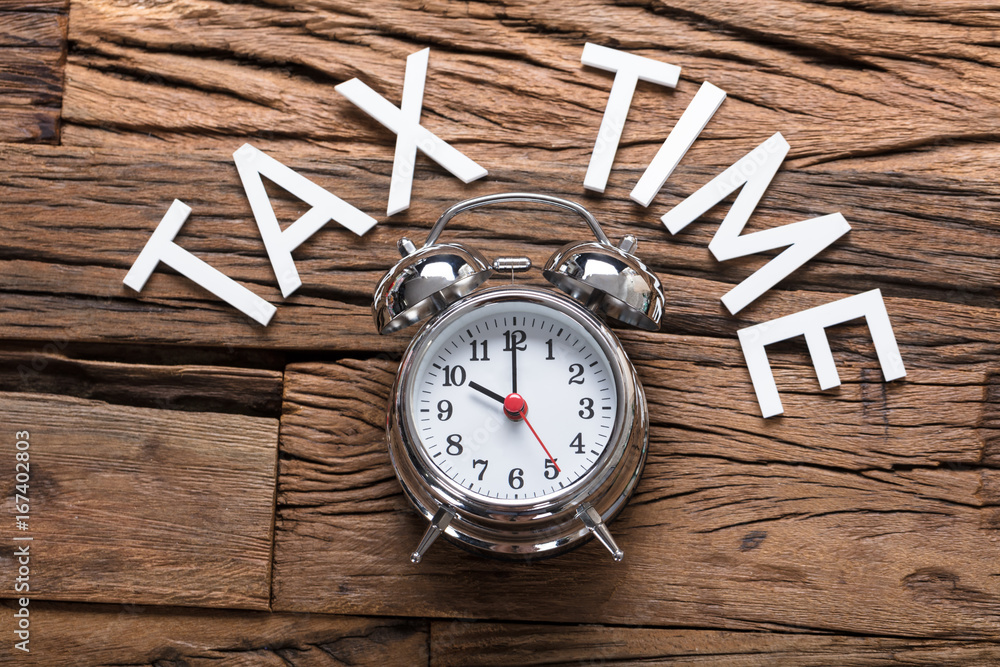 Tax Time Text By Alarm Clock On Wooden Table Tax Time Text By Alarm Clock On Wooden Table