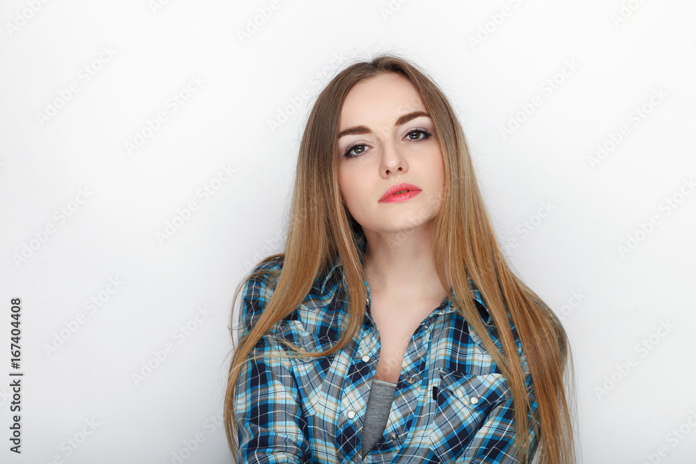 Beauty portrait of young adorable fresh looking blonde woman with hair chaos in blue plaid shirt. Emotion and facial expression concept. Beauty portrait of young adorable fresh looking blonde woman with hair chaos in blue plaid shirt. Emotion and facial expression concept.