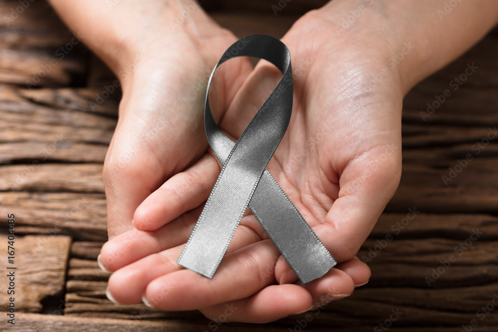 Human Hand Showing Grey Ribbon To Support Breast Cancer Cause
