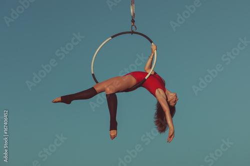 Woman is an aerial acrobat, she demonstrates the show on the hoop.