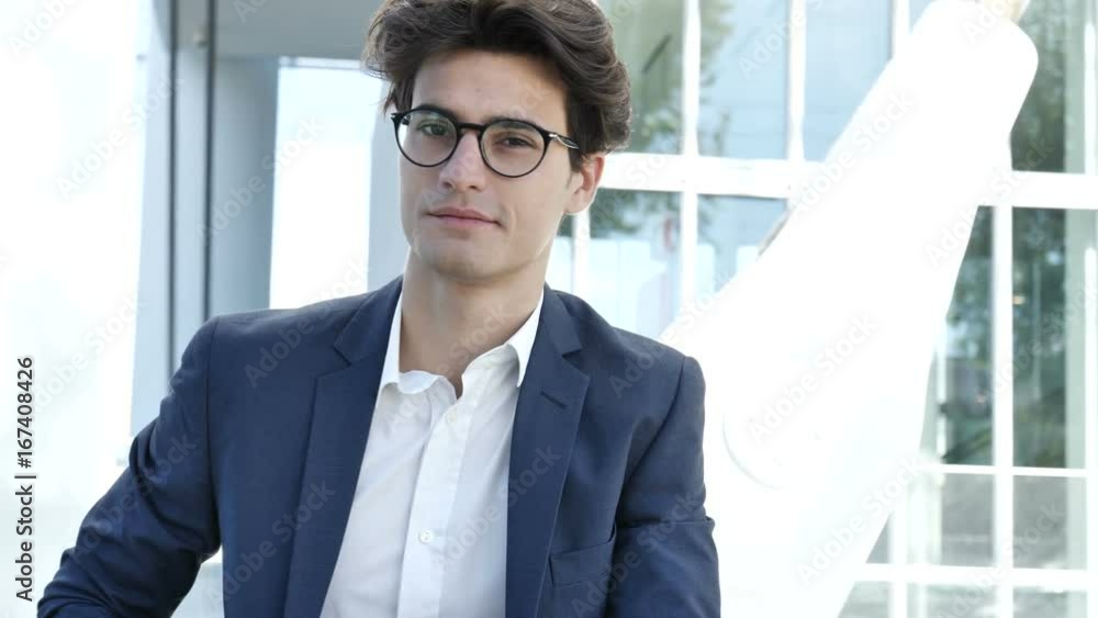 Stylish Young Handsome Man Standing in City Center Street, Looking at Camera Stylish Young Handsome Man Standing in City Center Street, Looking at Camera