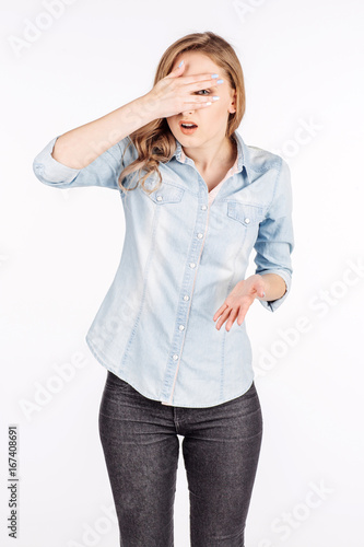 embarrassed female looking through her hands covering her face