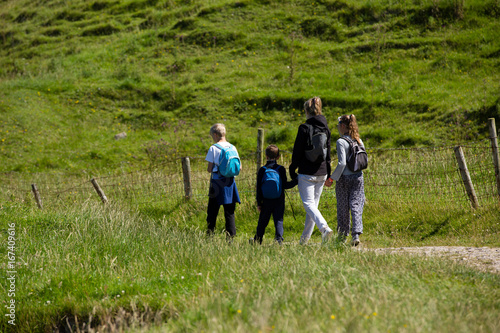 Northern Ireland landscape, hiking family on pathway, next to a fence © Belphnaque