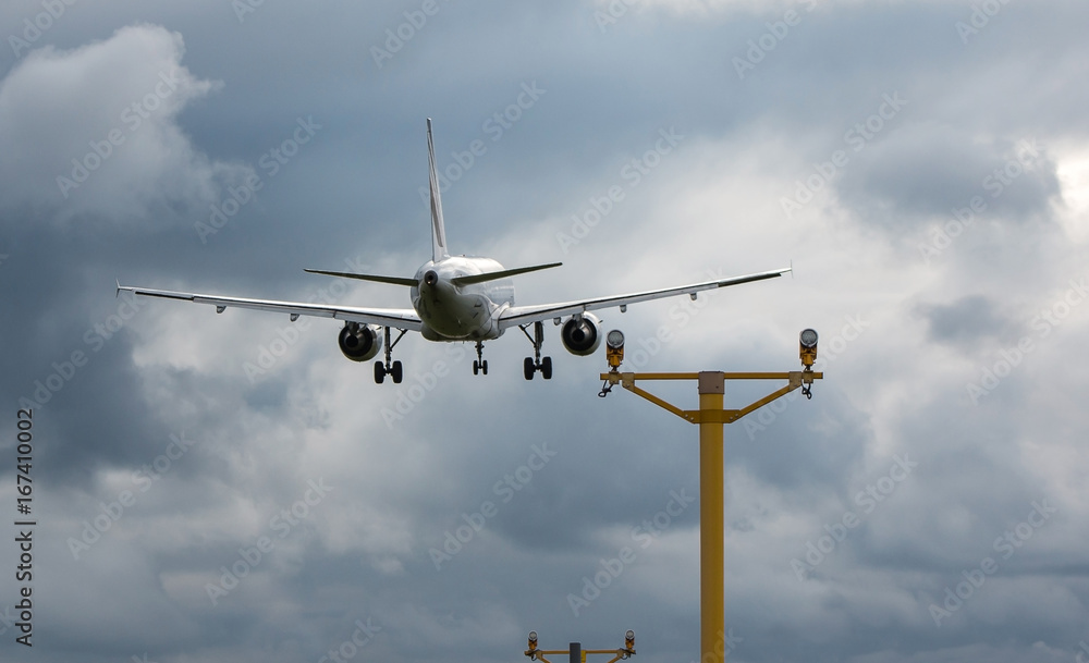Passenger plane landing on the airport during the stormy weather Passenger plane landing on the airport during the stormy weather