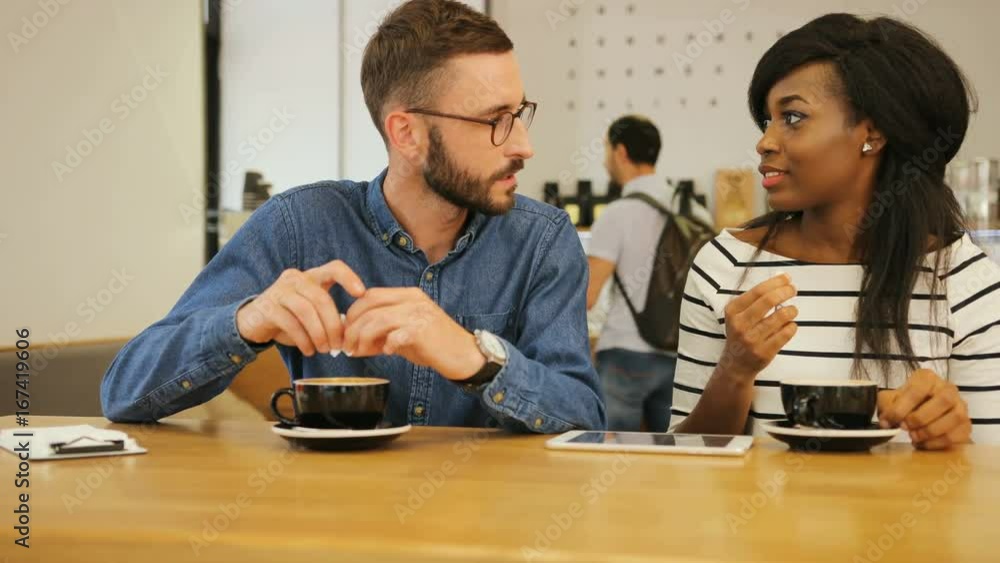 Young attractive hipster drinking coffee with here female friend in the stylish cafe. Portrait shot. Young attractive hipster drinking coffee with here female friend in the stylish cafe. Portrait shot.