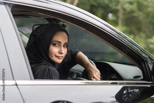 Happy muslim woman inside her new car.