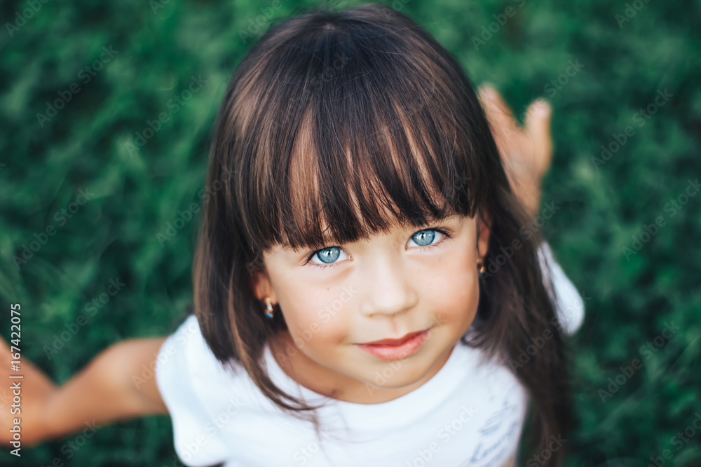 Close portrait of very beautiful little girl with a bang, dark hair and blue  eyes Stock Photo | Adobe Stock