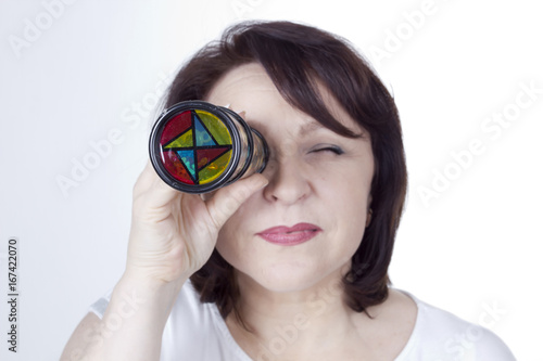 Adult woman looking into a kaleidoscope photo