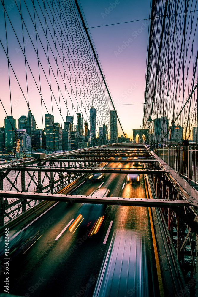 Fototapeta premium Brooklyn Bridge, Downtown Manhattan, Nowy Jork. Nocna scena. Lekkie szlaki. Miejskie światła. Koncepcja miejskiego życia i transportu