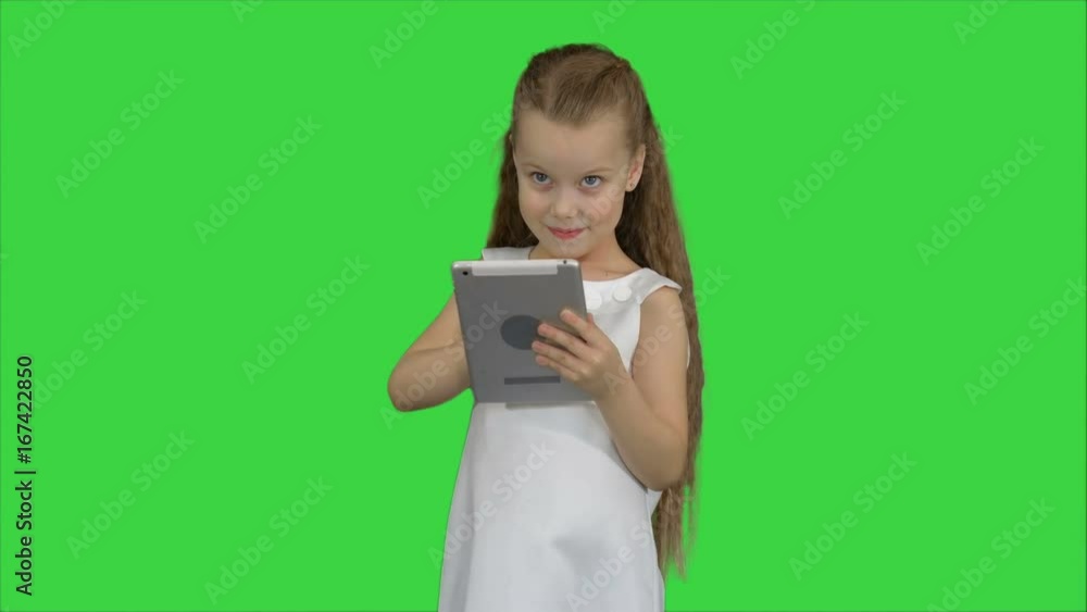 Small girl using tablet computer on a Green Screen, Chroma Key Small girl using tablet computer on a Green Screen, Chroma Key