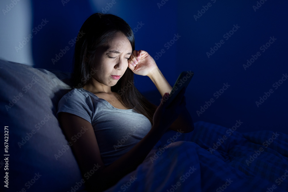 Woman feeling tired with using mobile phone on bed Woman feeling tired with using mobile phone on bed