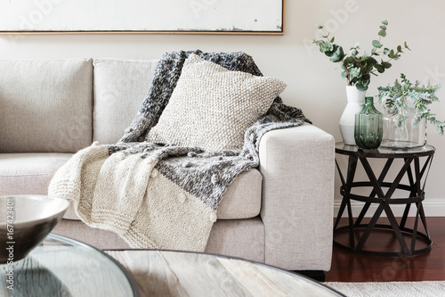Textured layers interior styling of cushion sofa and throw in nuetral colors photo