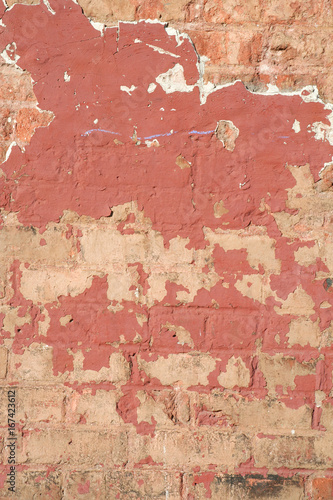 Red Paint Peeling off old orange Brick Wall