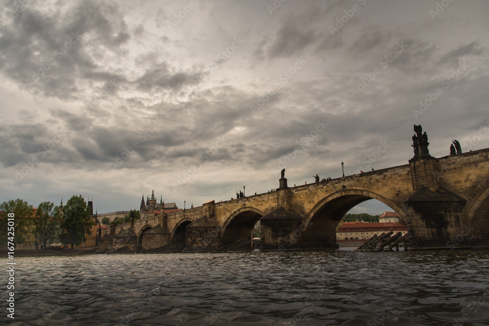 Dramatic Prague Castle with cloudy sunset and Charles Bridge .
