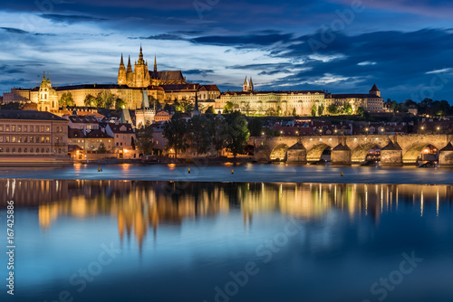Prague Castle with cloudy sunset blue sky and Charles Bridge light up