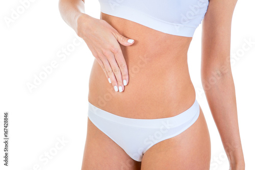 Slim female body in white underwear, with hand on her belly, on a white background © sasapanchenko