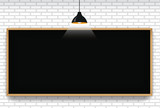 Blank blackboard in white brick wall background with hanging light