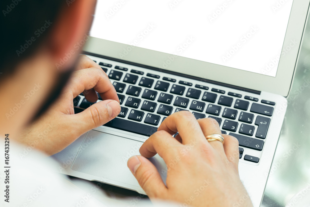 Young man performs work on a laptop Young man performs work on a laptop