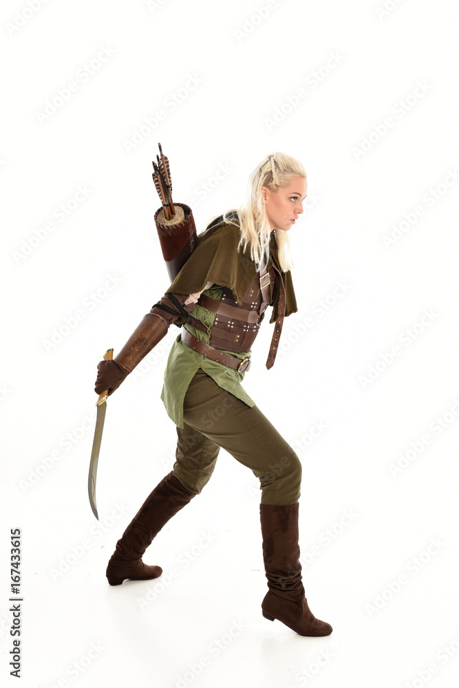 full length portrait of a blonde girl wearing green and brown medieval costume. standing pose isolated on white background. full length portrait of a blonde girl wearing green and brown medieval costume. standing pose isolated on white background.
