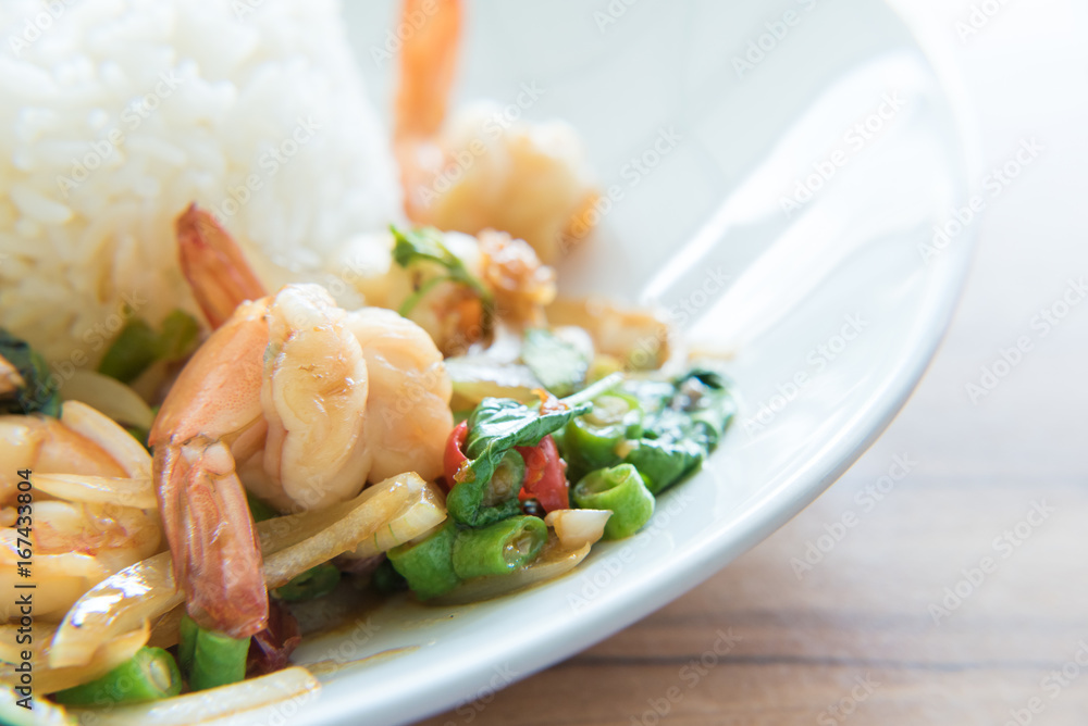 Stir-Fried Shrimps and Basil Rice Thai Food style has ready to served on white plate.