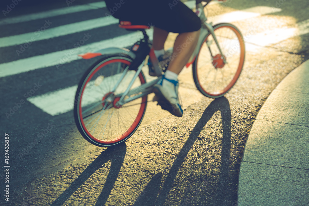 low section of man riding a bike crossing zebra crossing,China. low section of man riding a bike crossing zebra crossing,China.