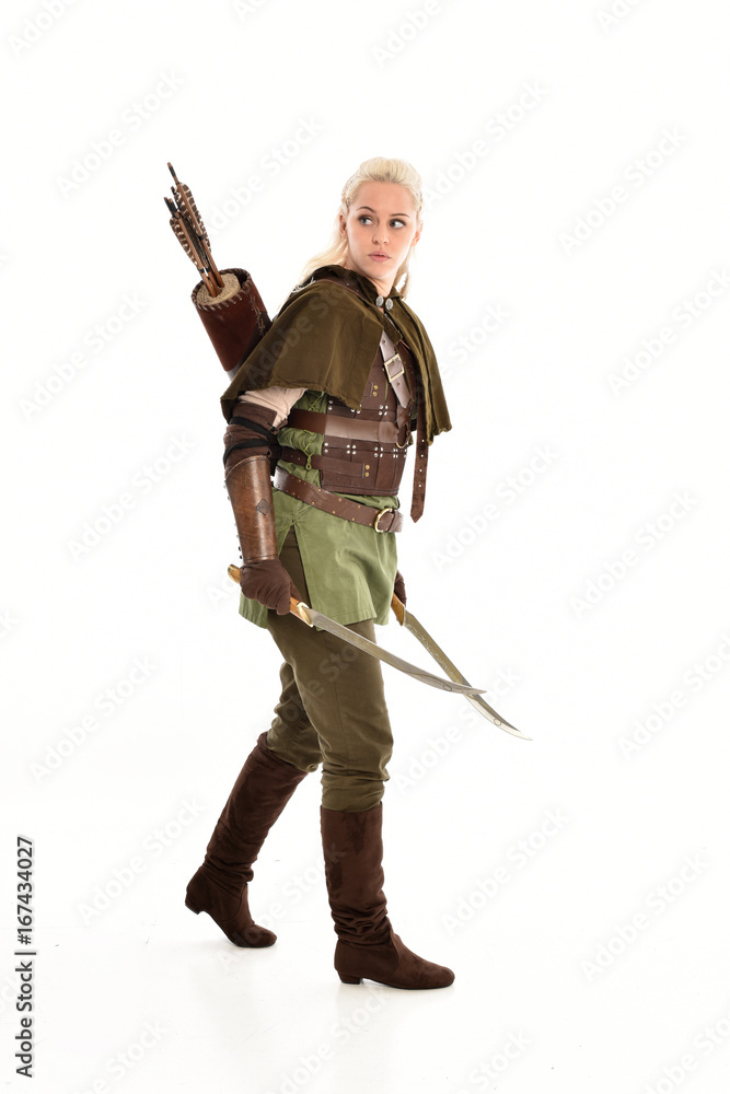 full length portrait of a blonde girl wearing green and brown medieval costume. standing pose isolated on white background. full length portrait of a blonde girl wearing green and brown medieval costume. standing pose isolated on white background.