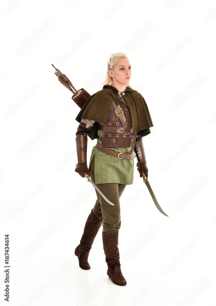 full length portrait of a blonde girl wearing green and brown medieval costume. standing pose isolated on white background. full length portrait of a blonde girl wearing green and brown medieval costume. standing pose isolated on white background.