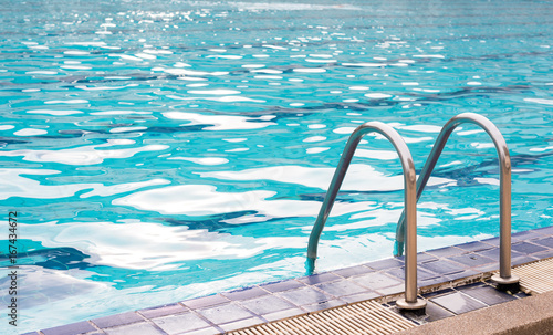 Grab bars ladder in the blue swimming pool