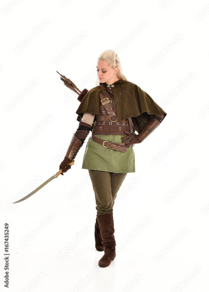 full length portrait of a blonde girl wearing green and brown medieval costume. standing pose isolated on white background. full length portrait of a blonde girl wearing green and brown medieval costume. standing pose isolated on white background.