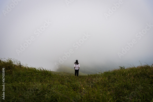 Girl has looking for way to the mountain in the heavy mist and cloudy.