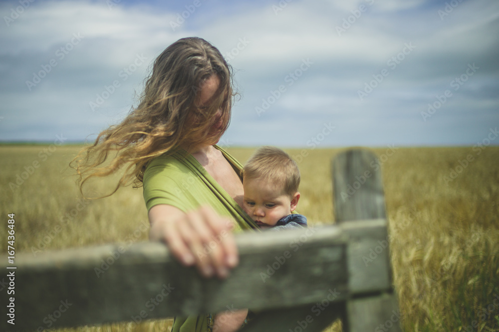 Young woman with baby opening gate Young woman with baby opening gate