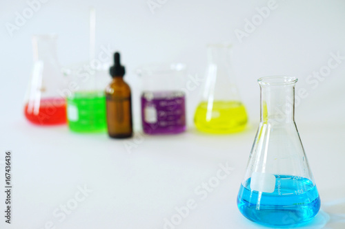 Group of Laboratory Glass Erlenmeyer Conical Flask and Beaker filled with chemical liquid for a chemistry experiment in a science research laboratory.