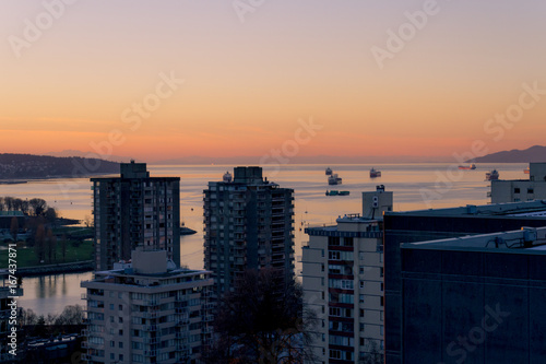 Morning cityscape with sunrise illuminating top of building