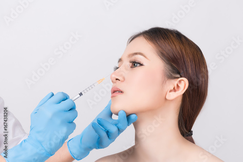 Beauty treatment concept : Female Doctors hands in gloves making an injection in face.