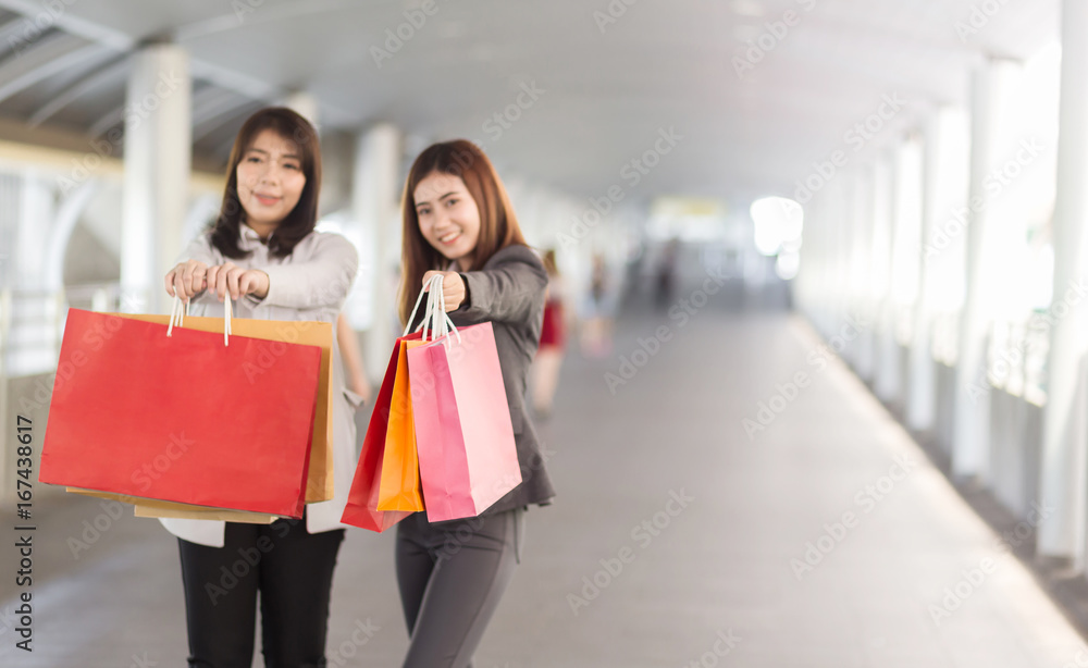 Soft focus On Bags. Beautiful two asian woman with shopping bags walking on the street. Soft focus On Bags. Beautiful two asian woman with shopping bags walking on the street.