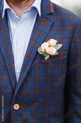 Groom with a wedding boutonniere in a checkered suit