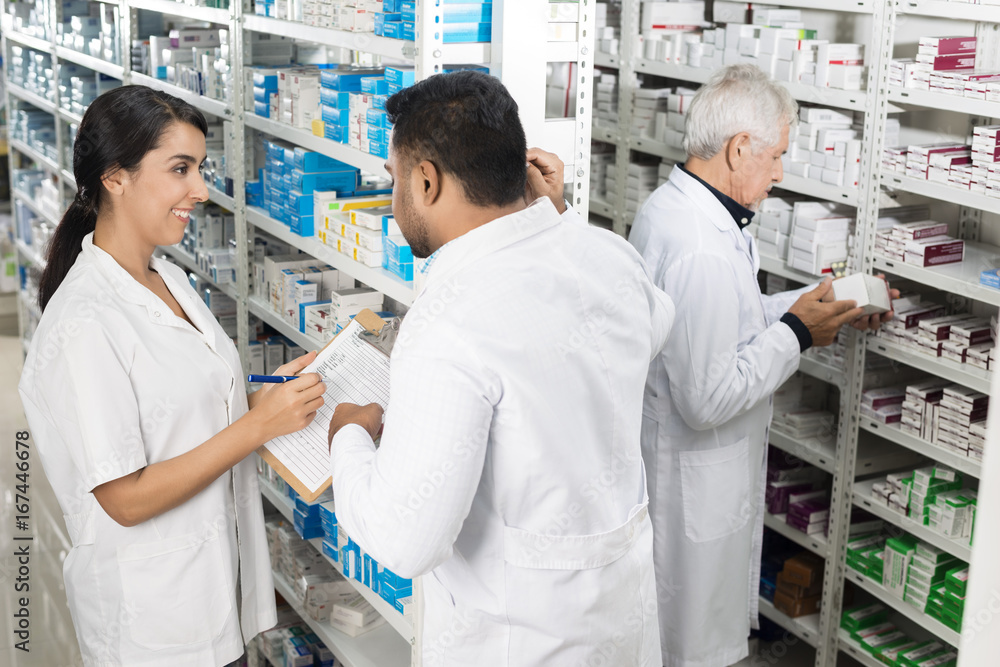 Obraz premium Pharmacists Working By Shelves In Pharmacy