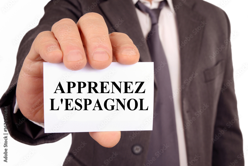 Homme tenant une carte sur laquelle est écrit apprenez l'espagnol Homme tenant une carte sur laquelle est écrit apprenez l'espagnol