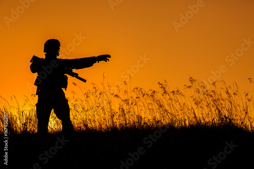 military soldier with weapons at sunset. shot, holding gun, colorful sky. military concept. © kaninstudio
