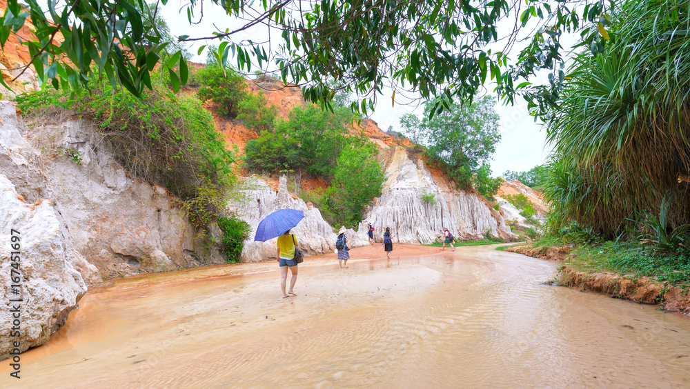 Mui Ne, Vietnam - February 19th, 2017: Tourists visit spring in ecotourism on spring day, mountain here unstructured natural stone beautiful by erosion of natural landscapes drawn in Mui Ne, Vietnam Mui Ne, Vietnam - February 19th, 2017: Tourists visit spring in ecotourism on spring day, mountain here unstructured natural stone beautiful by erosion of natural landscapes drawn in Mui Ne, Vietnam