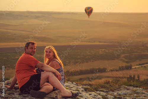 Loving couple on a rock top.