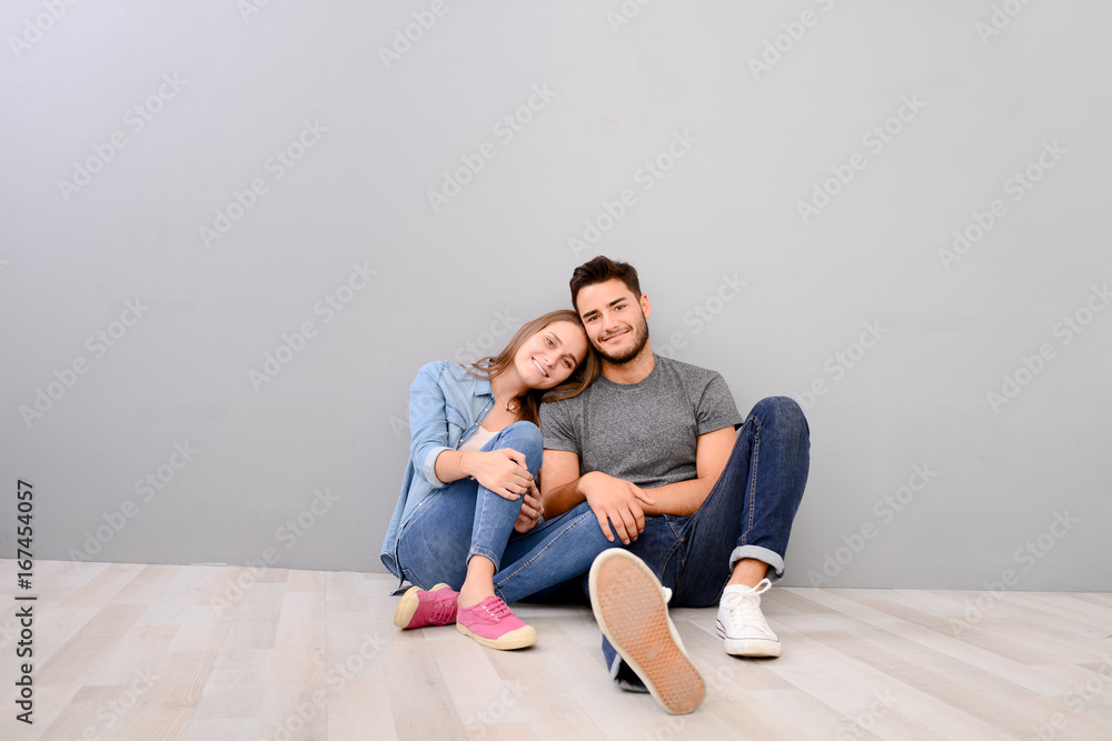 happy young lovely couple sitting on the floor of new home flat apartment with empty space happy young lovely couple sitting on the floor of new home flat apartment with empty space